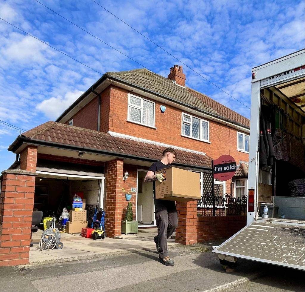 A Bellwoods mover carrying a box out to the removal van outside a sold house in Huddersfield