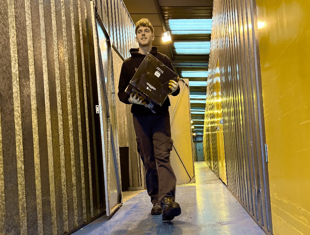 Bellwoods team member carrying a box through the indoor storage warehouse
