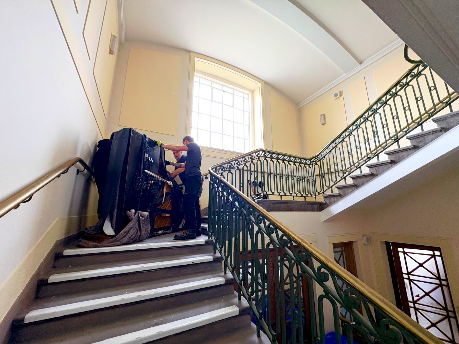 Bellwoods crew moving a covered Steinway grand piano up the staircase to the Civic Hall at Wallasey Town Hall